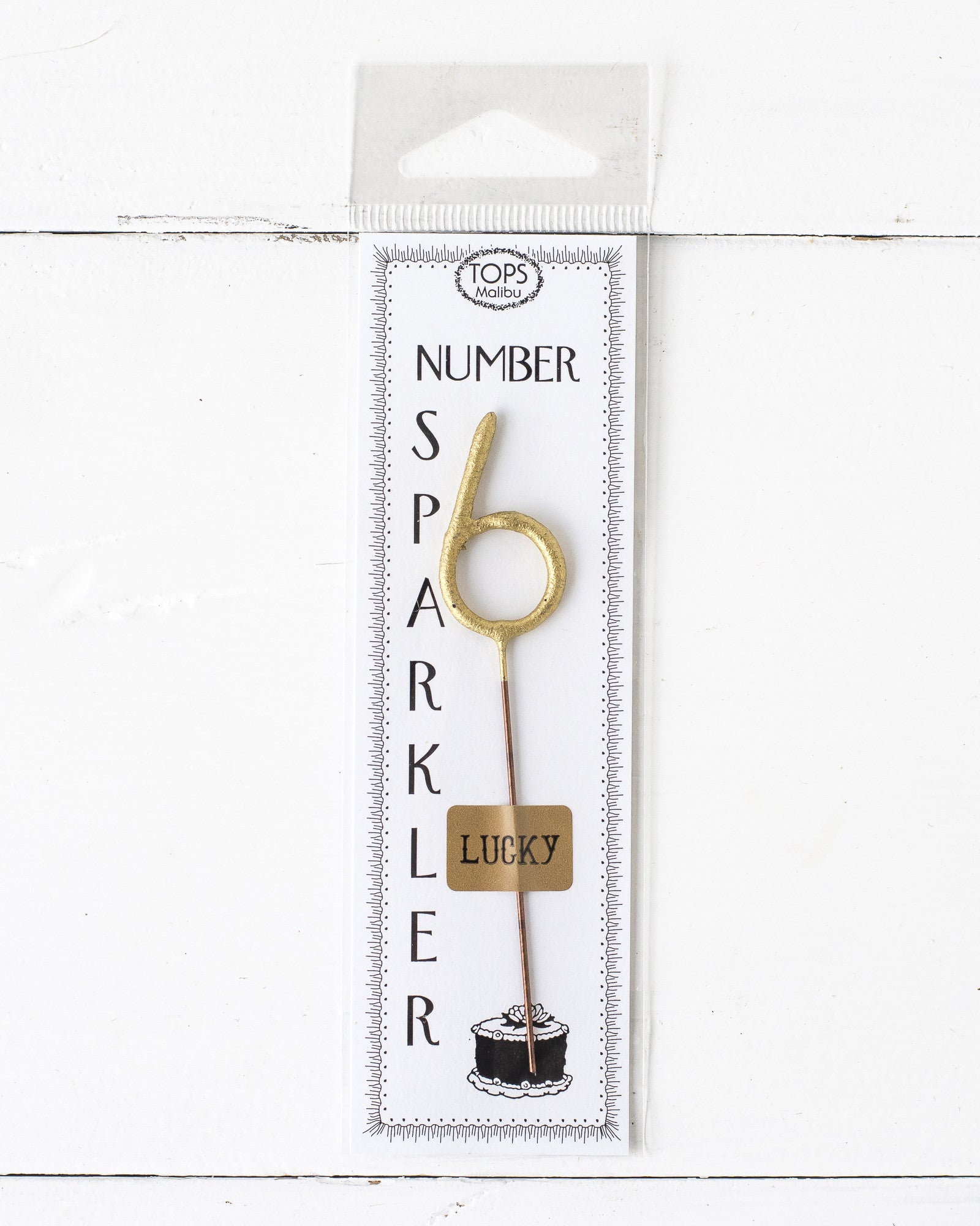 A Tops Malibu Gold Number Cake Topper Sparkler in a package on a white background.