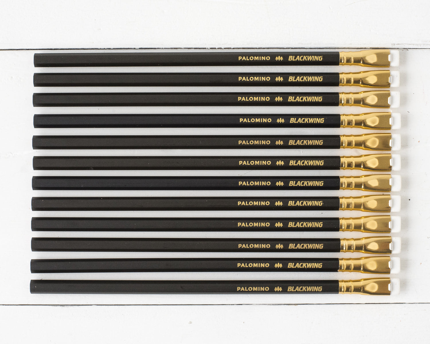 A collection of Blackwing Matte Pencil Set of 12 pencils arranged in parallel on a white surface.