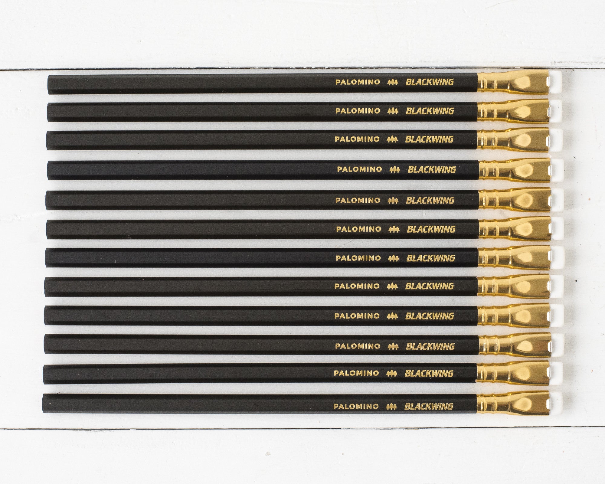 A collection of Blackwing Matte Pencil Set of 12 pencils arranged in parallel on a white surface.