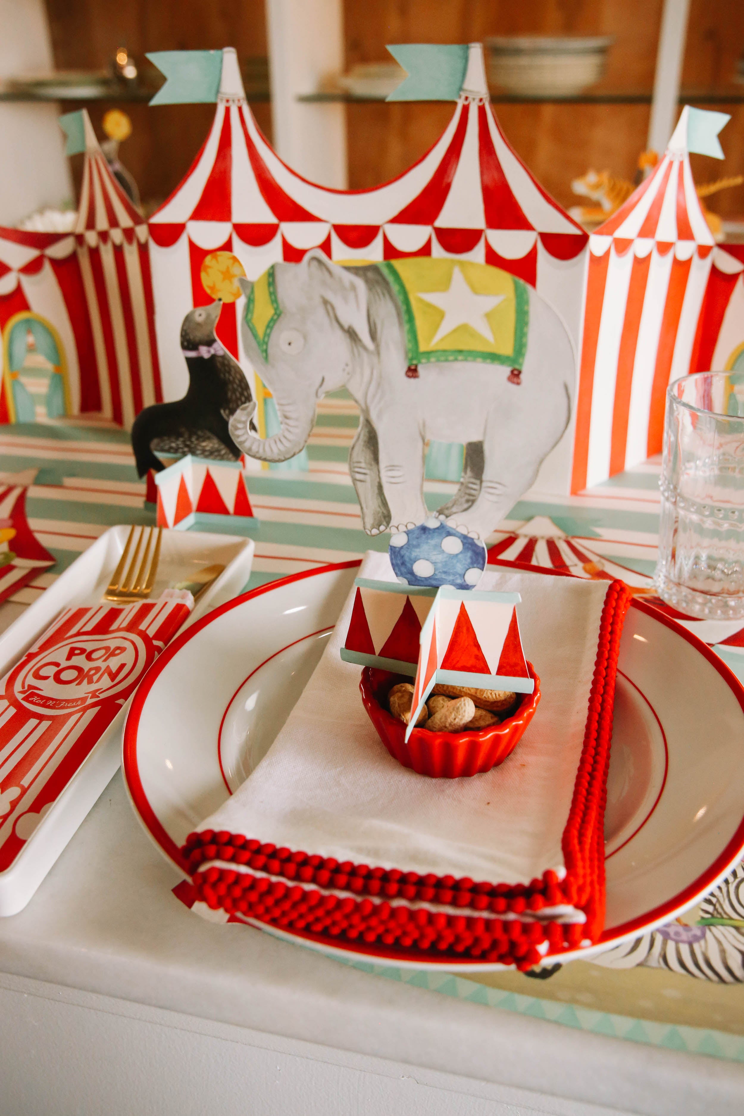 The Elephant Circus Trio Table Ornament sitting atop the plate in a circus-themed place setting.