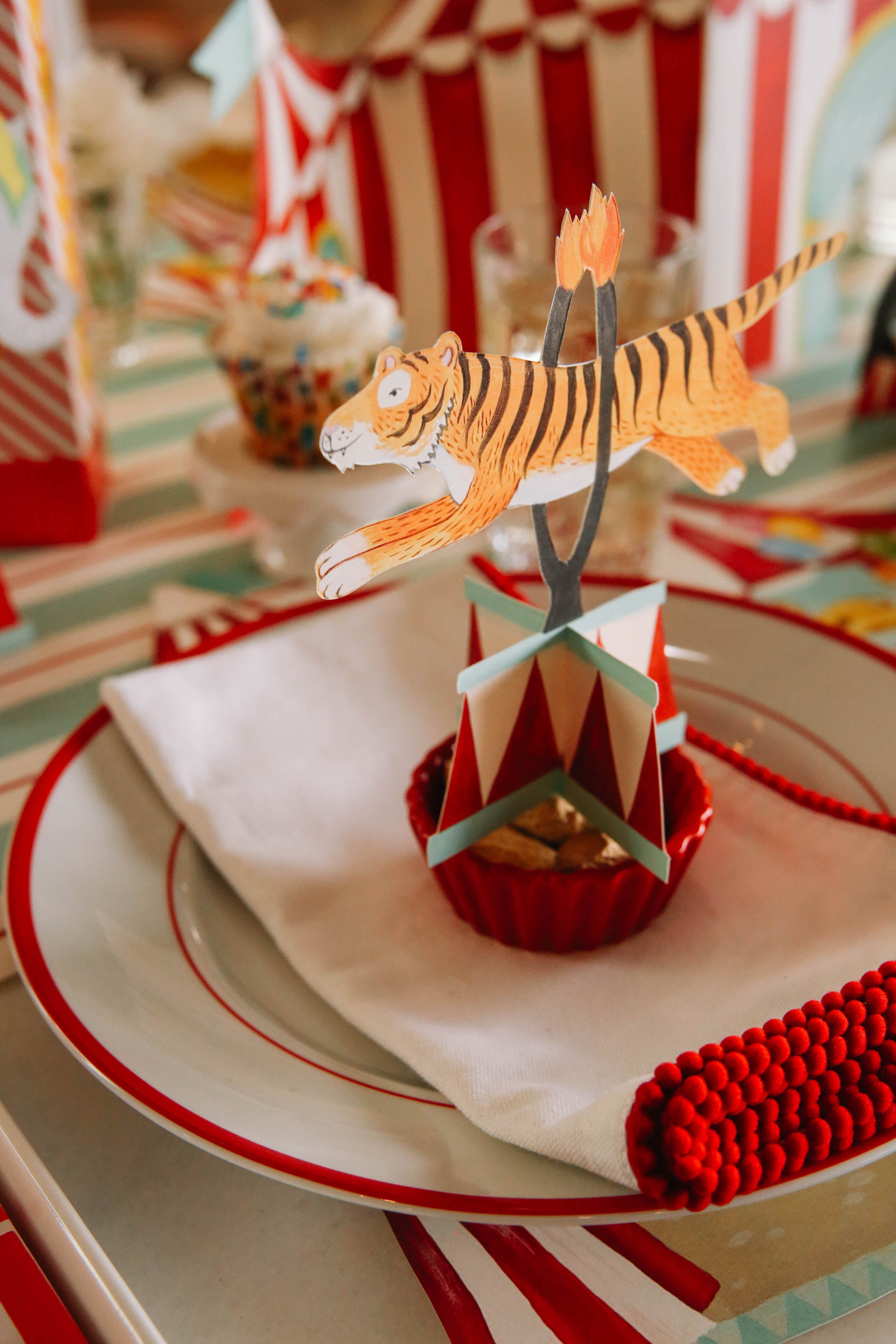 The Tiger Circus Trio Table Ornament sitting atop the plate in a circus-themed place setting.