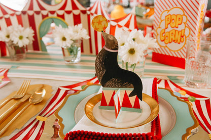 The Seal Circus Trio Table Ornament sitting atop the plate in a circus-themed place setting.
