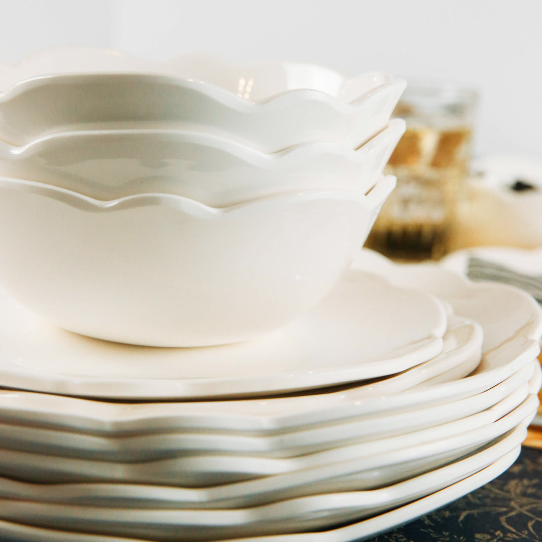 Stack of white Relish Dinnerware Scallop Cream Soup/Cereal Bowls on a table.