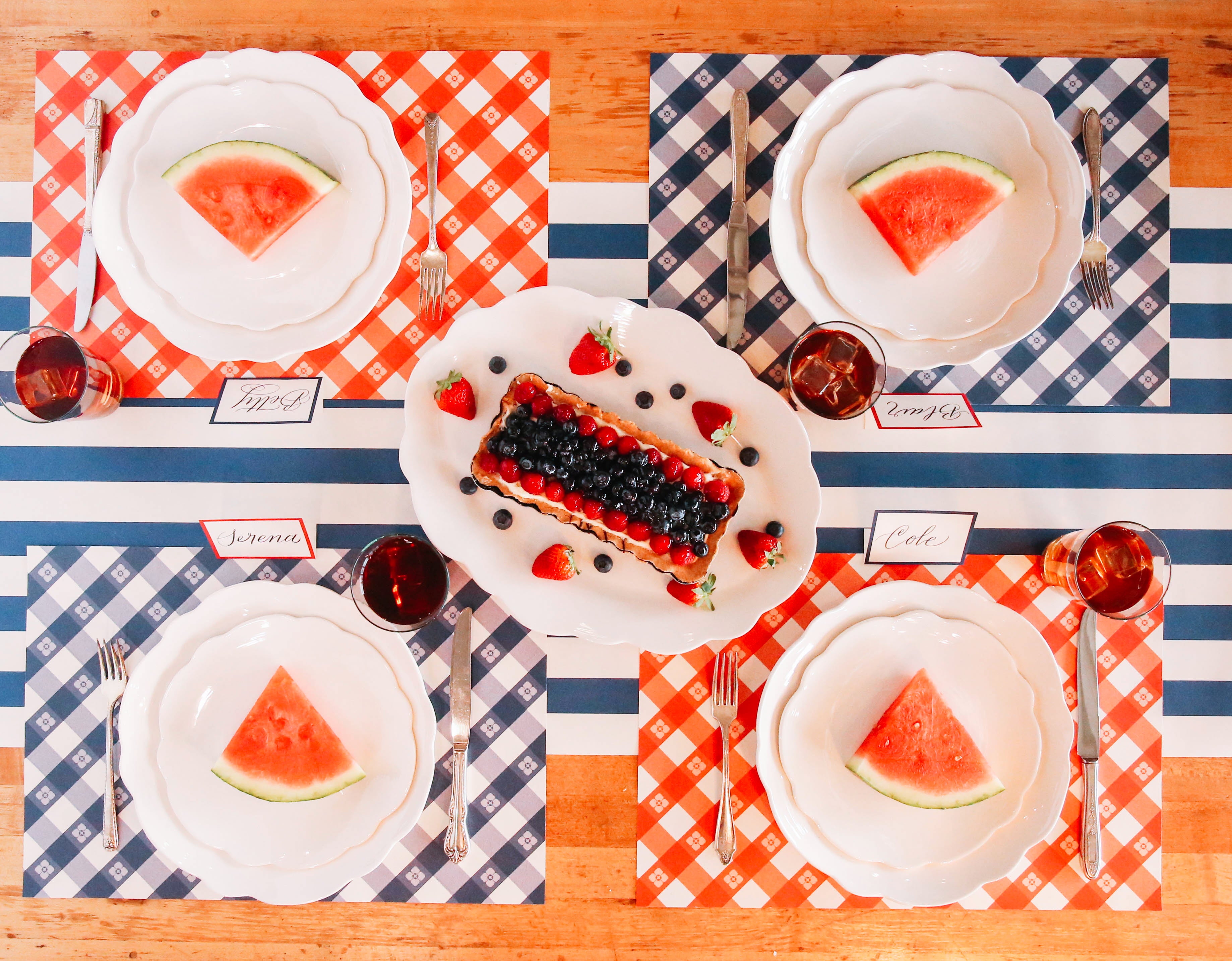 The red and blue Picnic Check Placemats under a picnic-themed table setting for four, from above.