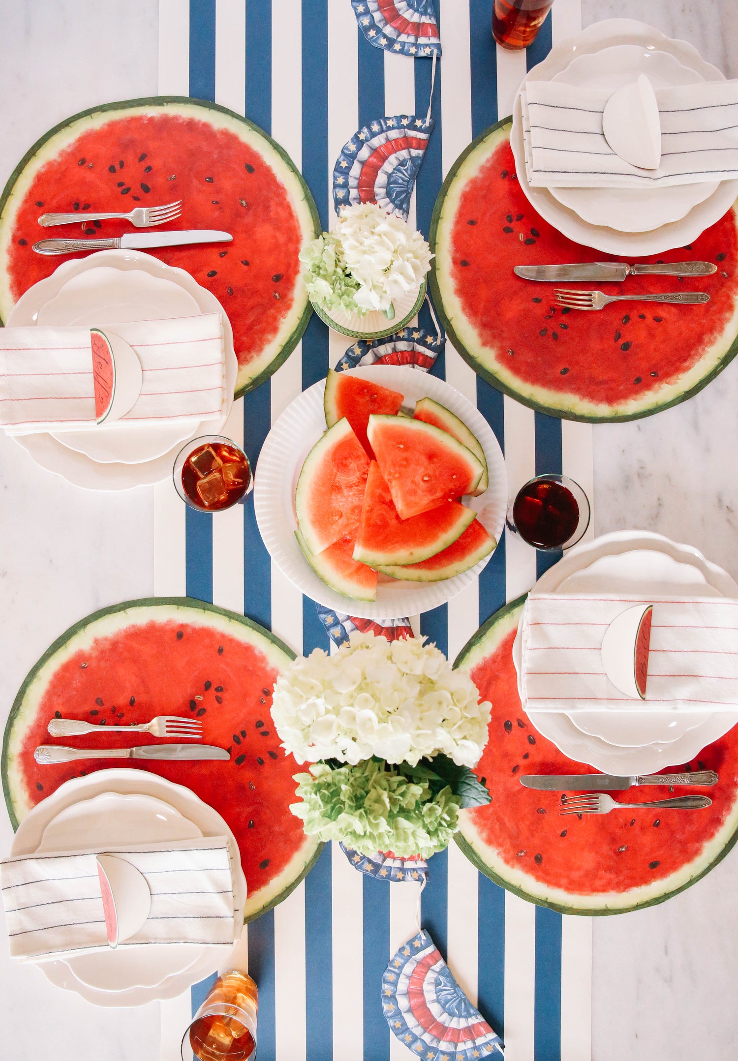 The Die-cut Watermelon Placemat under an elegant summertime table setting for four, from above.