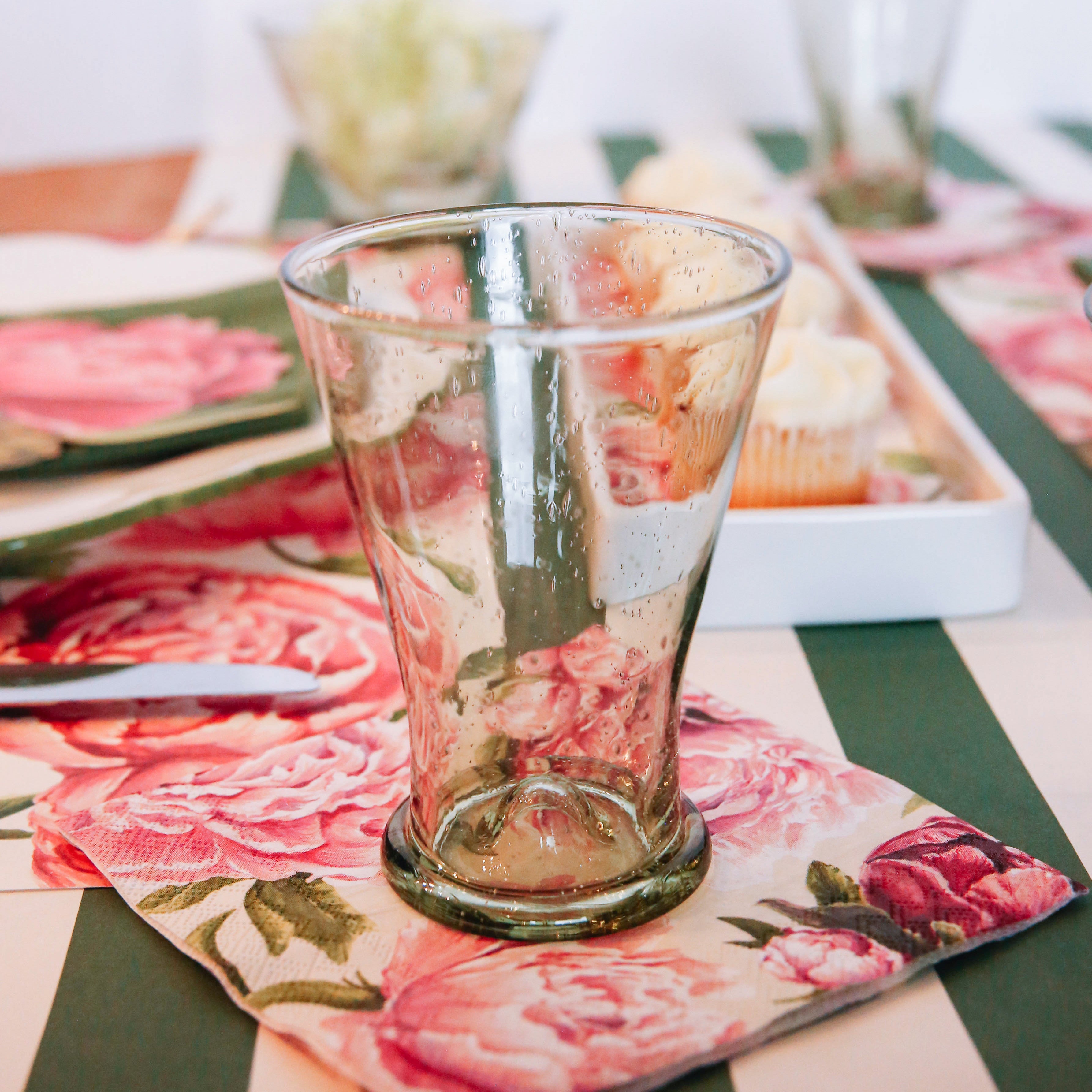 An elegant floral table setting featuring a Peony Cocktail Napkin under each water glass.