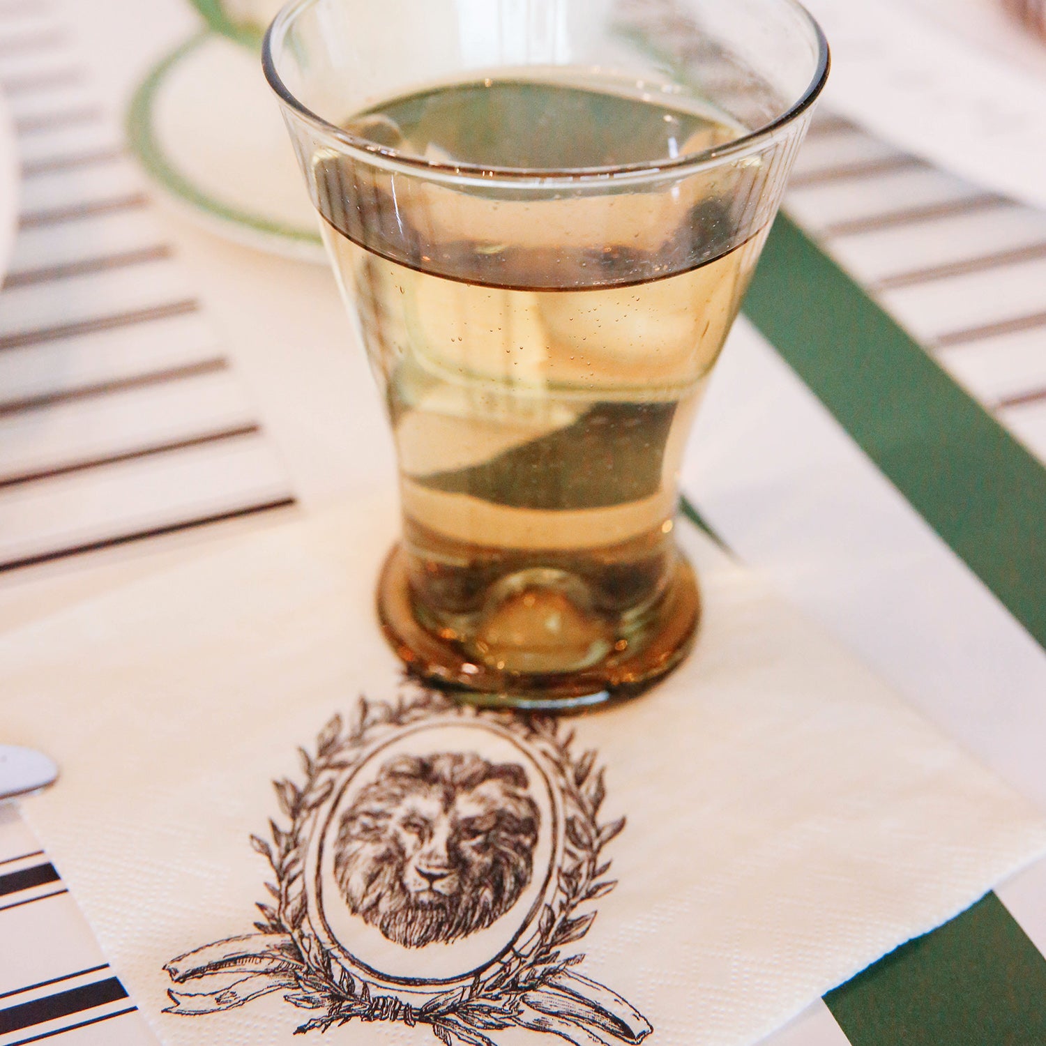 An elegant glass of water on a Majestic Crest Cocktail Napkin.