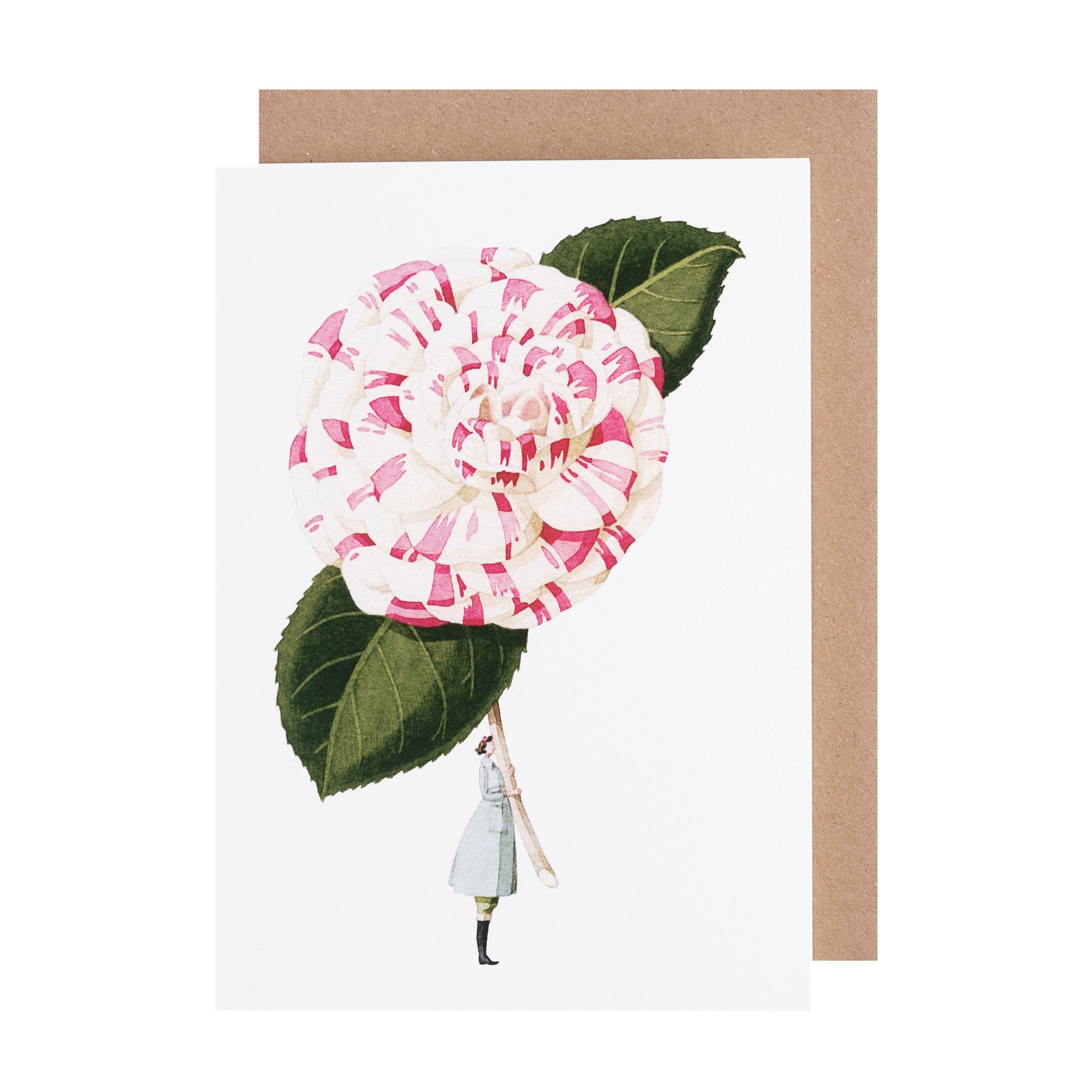 The Camellia Greeting Card features an illustration of a woman in a light blue dress holding a gigantic white and pink camellia flower with dark green leaves by the stem on a white background, with a kraft paper envelope.