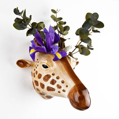 A Giraffe Ceramic head adorned with quirky purple flowers, a signature design from the British brand Quail Ceramics.