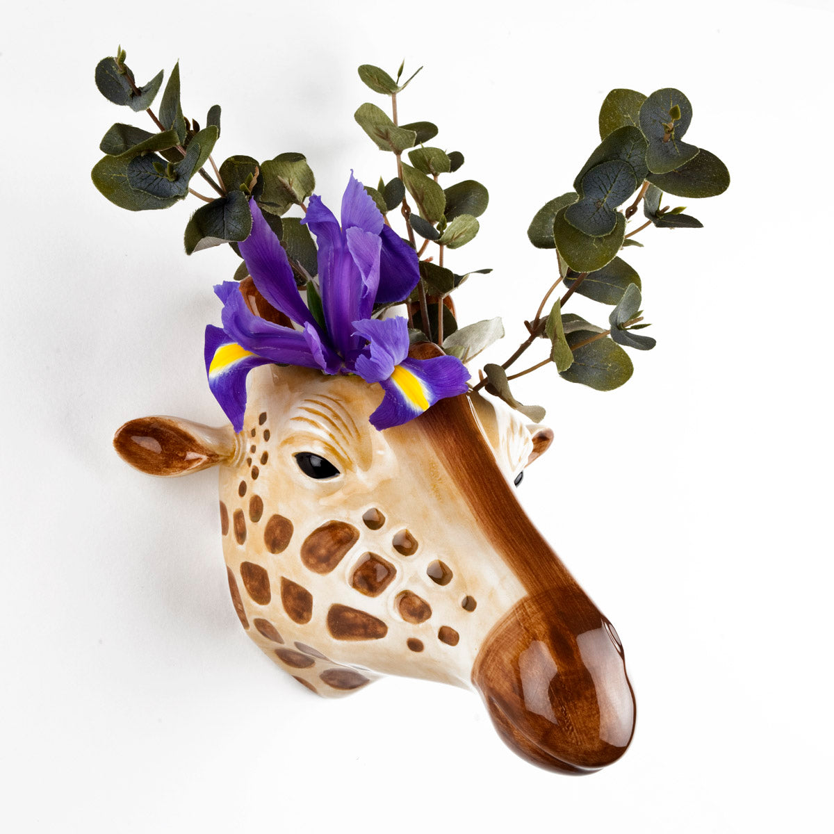 A Giraffe Ceramic head adorned with quirky purple flowers, a signature design from the British brand Quail Ceramics.