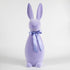 A group of colorful Large Flocked Button Nose Bunny figurines by Glitterville, celebrating Easter festivities, are lined up on a white background.
