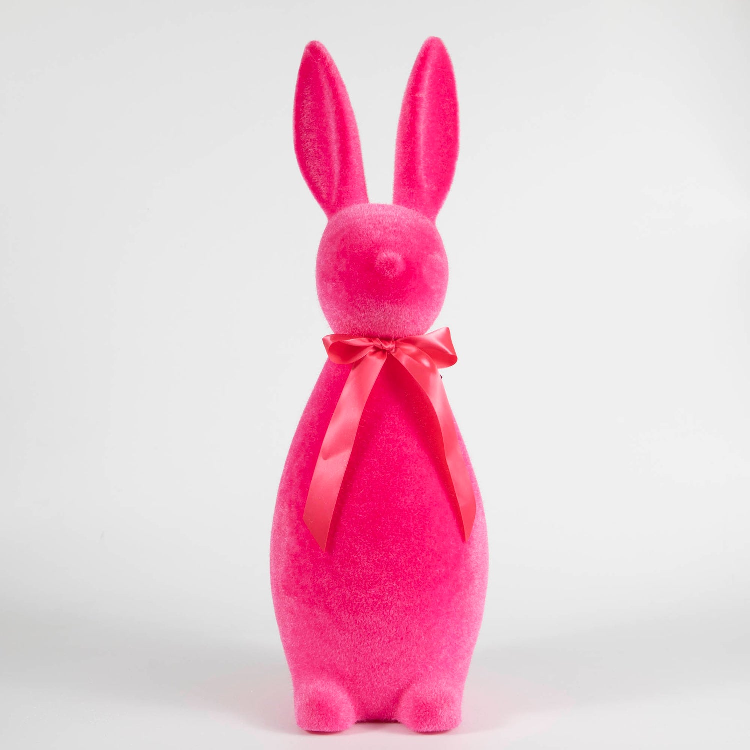A group of colorful Large Flocked Button Nose Bunny figurines by Glitterville, celebrating Easter festivities, are lined up on a white background.