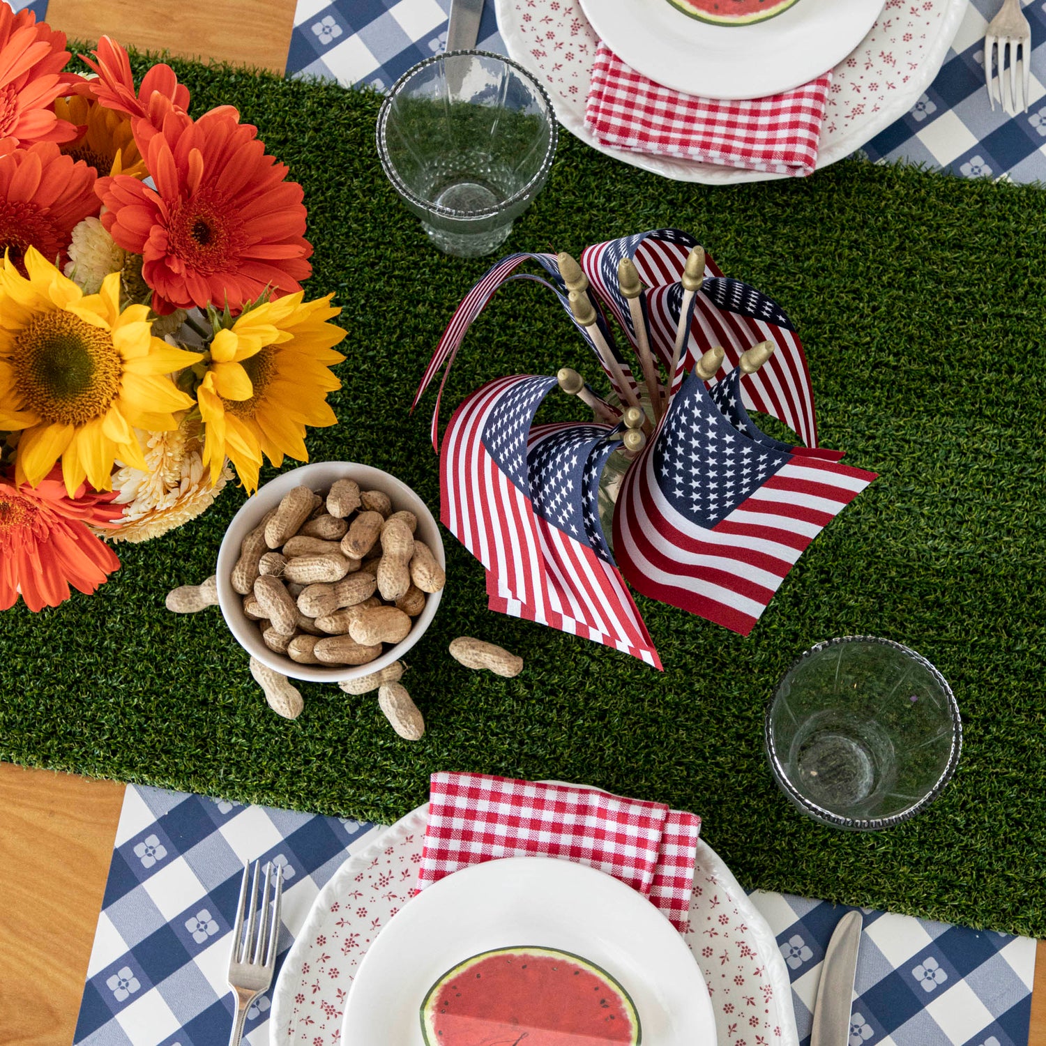 An artfully decorated table set for a 4th of July party with a Talking Tables Artificial Grass Table Runner.