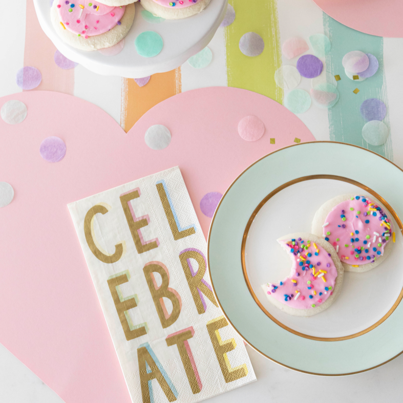 A table setting with a plate of Hester & Cook Die-cut Pink Heart Placemat and confetti.