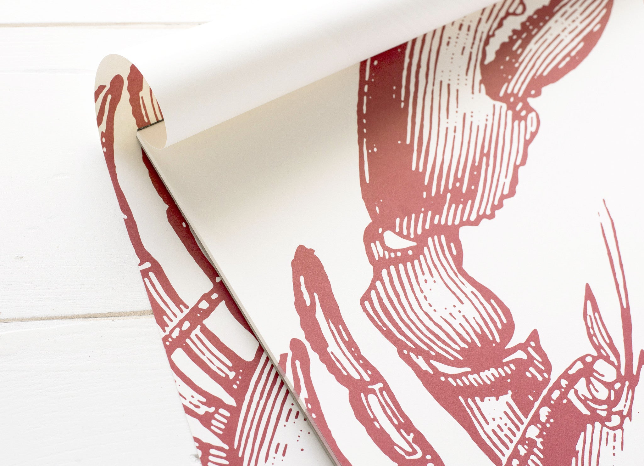 Close-up of the upper left corner of the Lobster Paper Placemats pad, showing a lobster claw in detail and the top sheet flipped back.