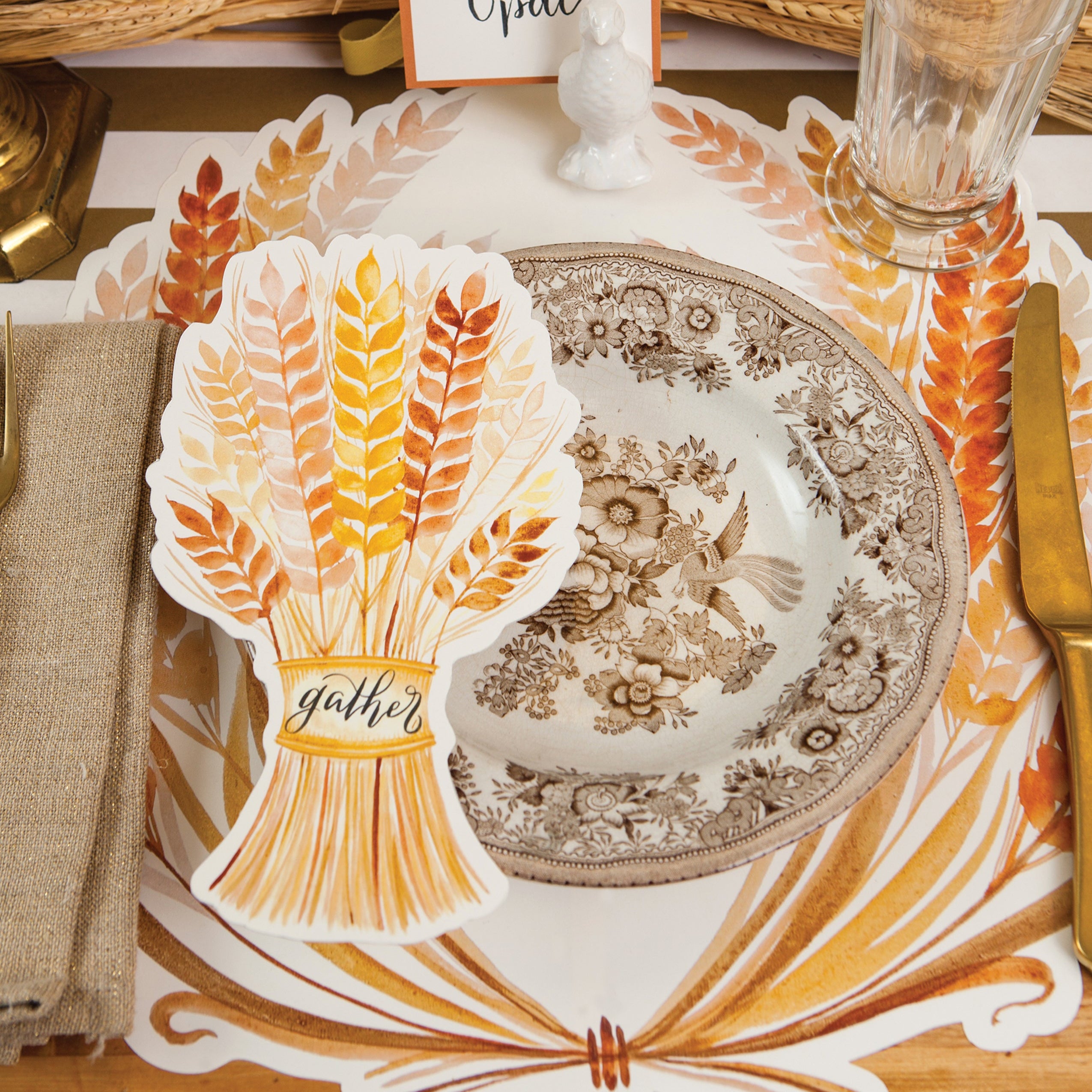 An elegant fall place setting with a Golden Harvest Table Accent with "Gather" written on it in lovely script resting on the plate.