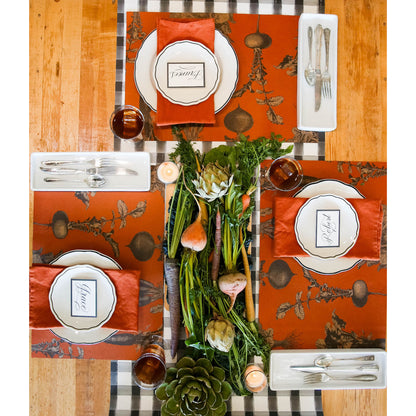 The Harvest Vegetable (Persimmon) Placemat under a rustic table setting for four, from above.