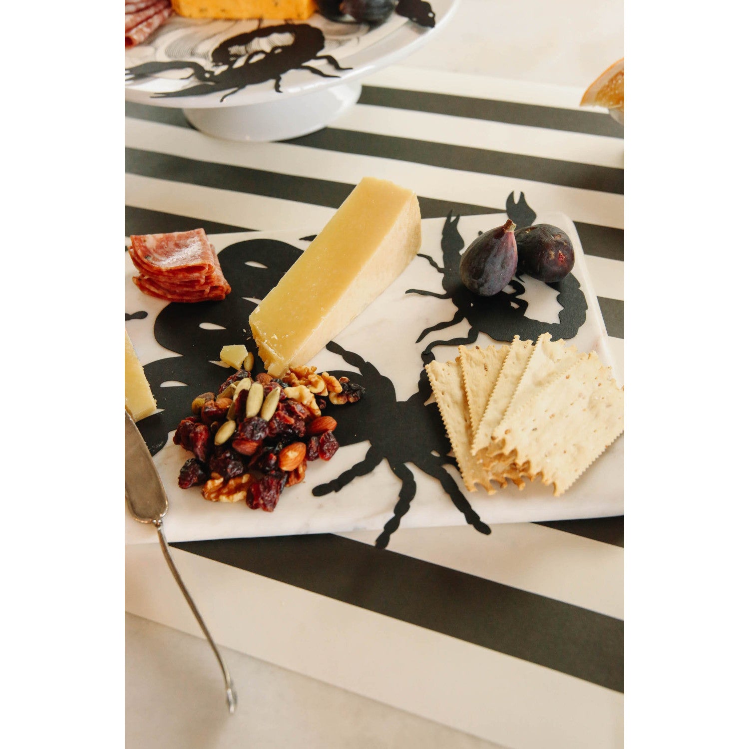 Die-cut, black paper cutouts of a rat, a snake, a spider and a scorpion.