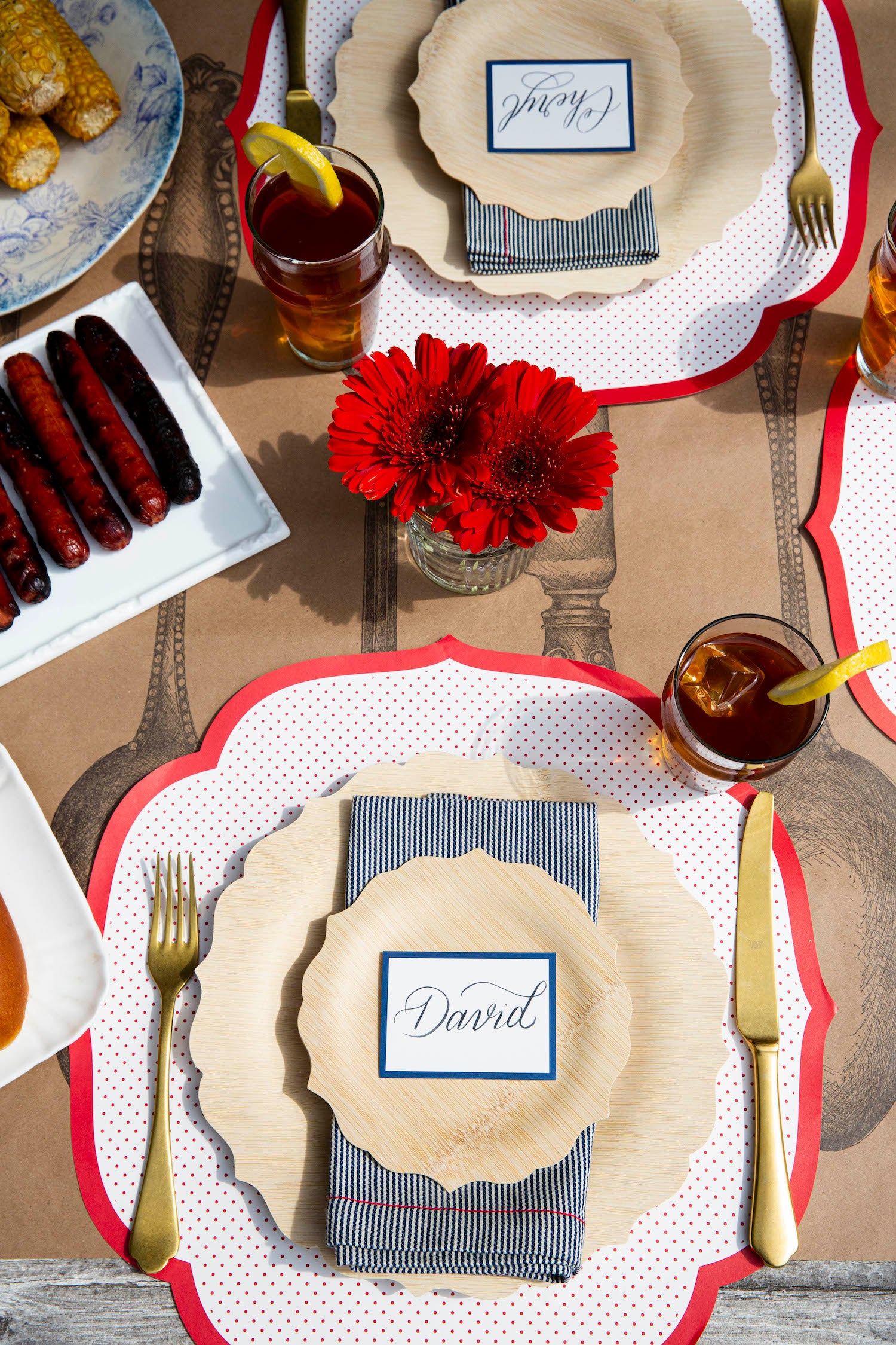 A tablescape with the Die-cut Red Swiss Dot Placemat by Hester &amp; Cook, plate, napkin, and utensils.