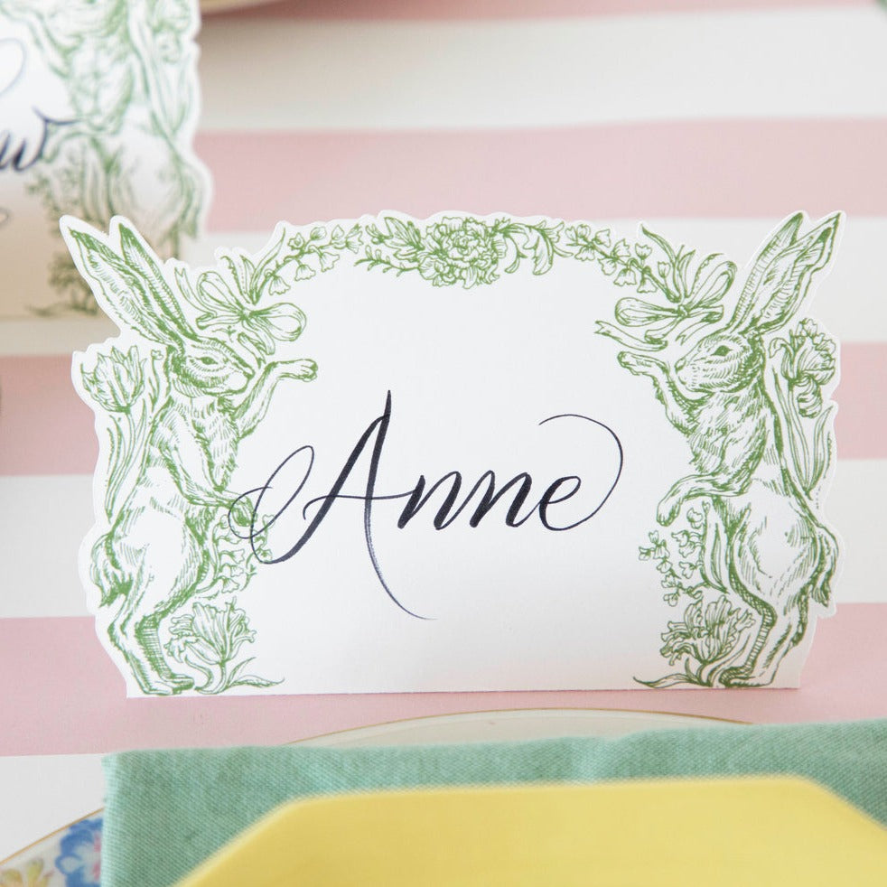 Close-up of a Greenhouse Hare Place Card labeled &quot;Anne&quot; on an elegant Easter table.