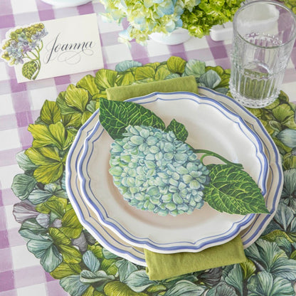 A Hydrangea Table Accent resting on the plate of an elegant floral place setting.