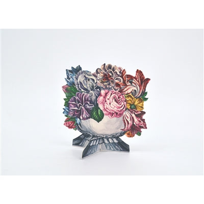 A die-cut, illustrated table ornament that stands up on its own, featuring a silver vase full of richly colored blooms in white, pink, red, orange, yellow, blue, and purple with green leaves.