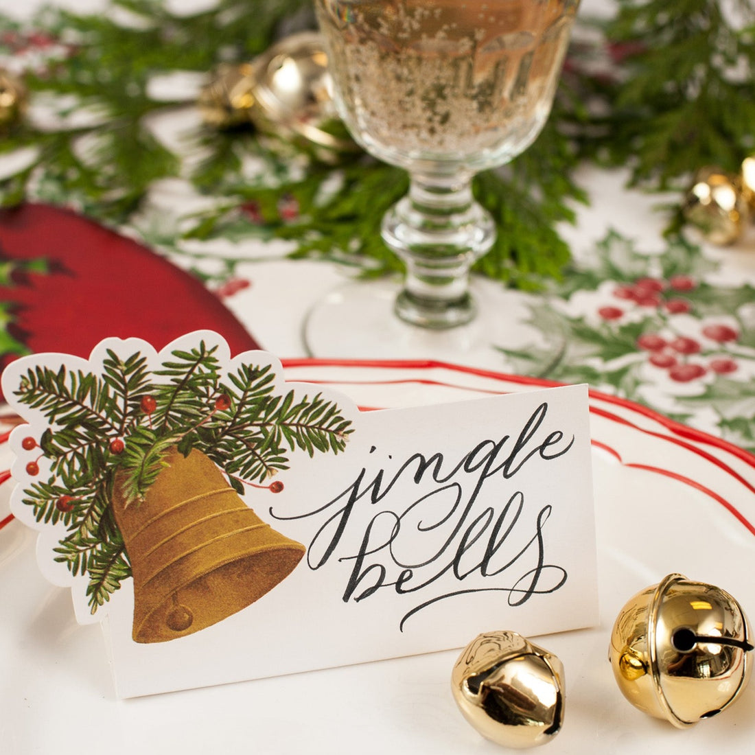 Close-up of a Bell Place Card reading &quot;jingle bells&quot; on a festive holiday place setting.