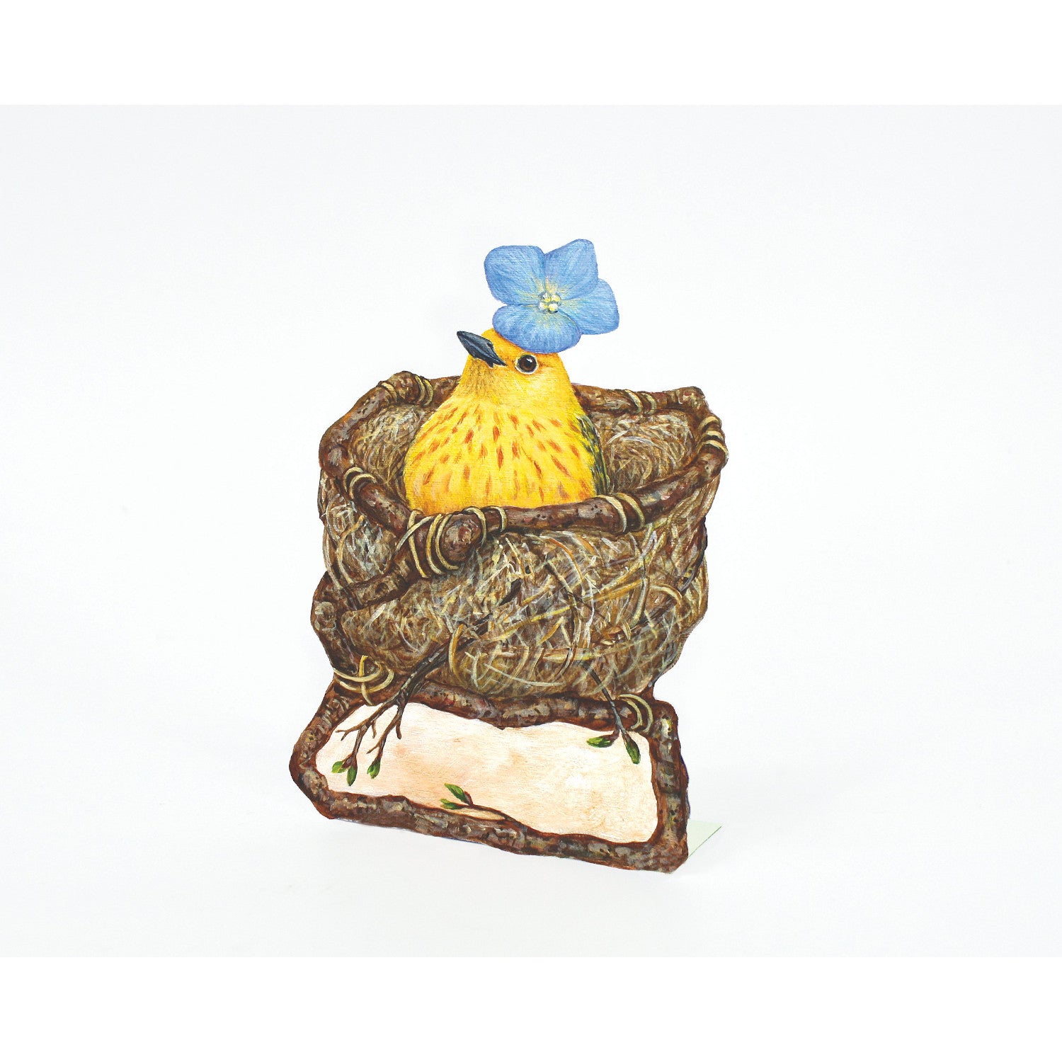 A die-cut freestanding place card featuring artwork of a bright yellow bird with a blue blossom adorning its head, sitting in a brown twiggy nest. Under the nest is a blank cream rectangle framed with twigs, for personalization.