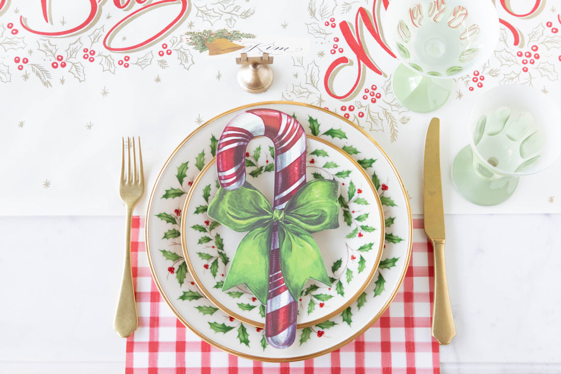 A festive Christmas place setting featuring a Candy Cane Table Accent resting on the plate.