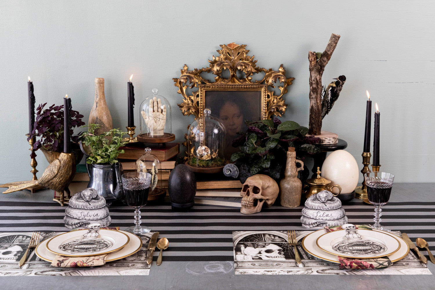 A spooky Halloween themed tablescape featuring Coiled Snake Place Cards behind each plate.