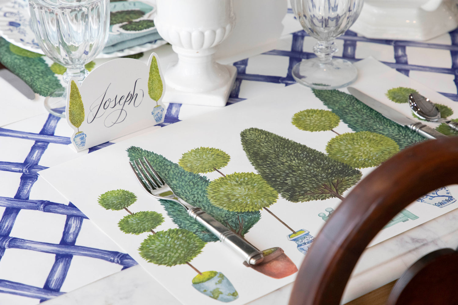 The Blue Lattice Runner under an elegant topiary-themed place setting, at an angle.