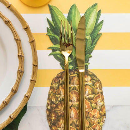 Close-up of a Pineapple Table Accent under the cutlery of a tropical place setting.