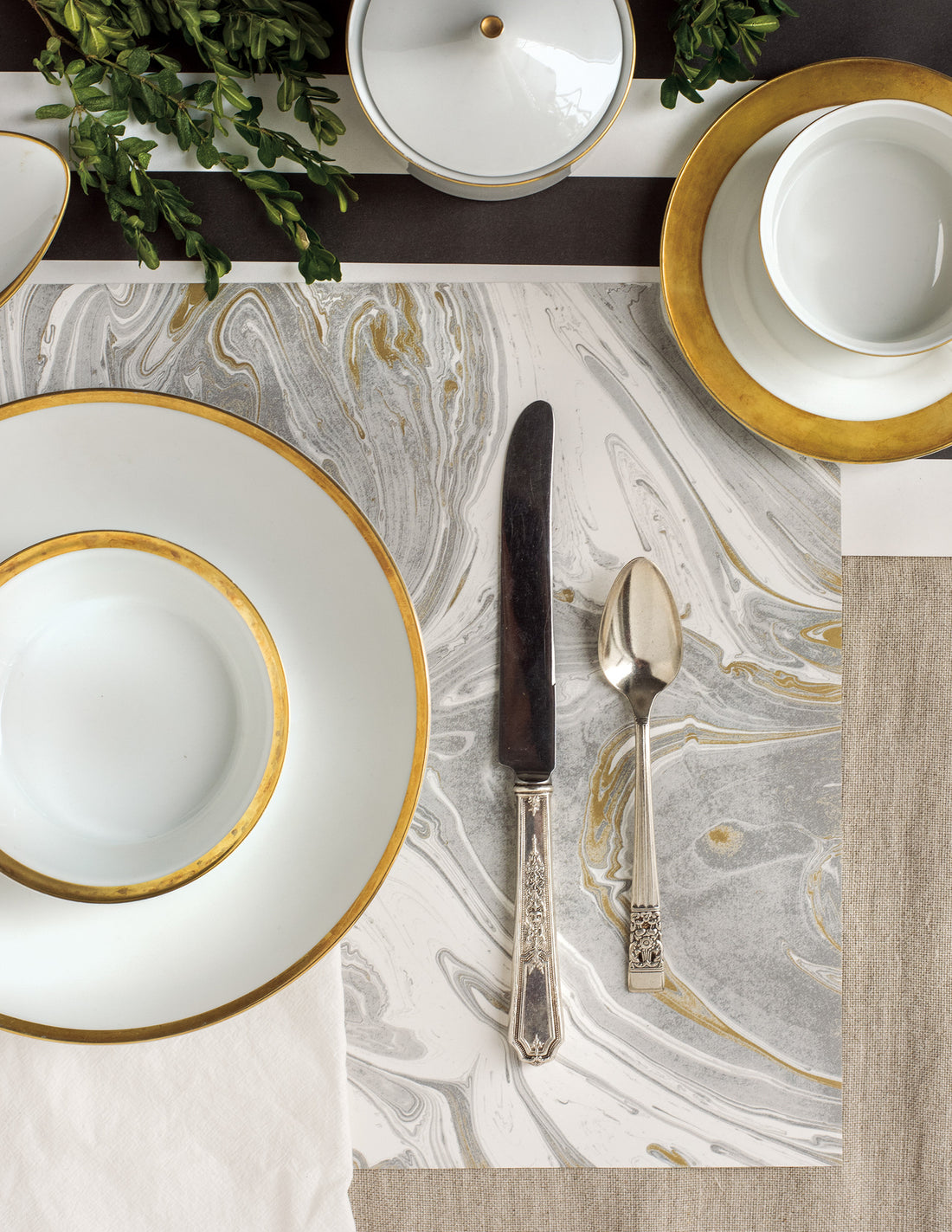 The Gray &amp; Gold Marbled Placemat under an elegant place setting, from above.