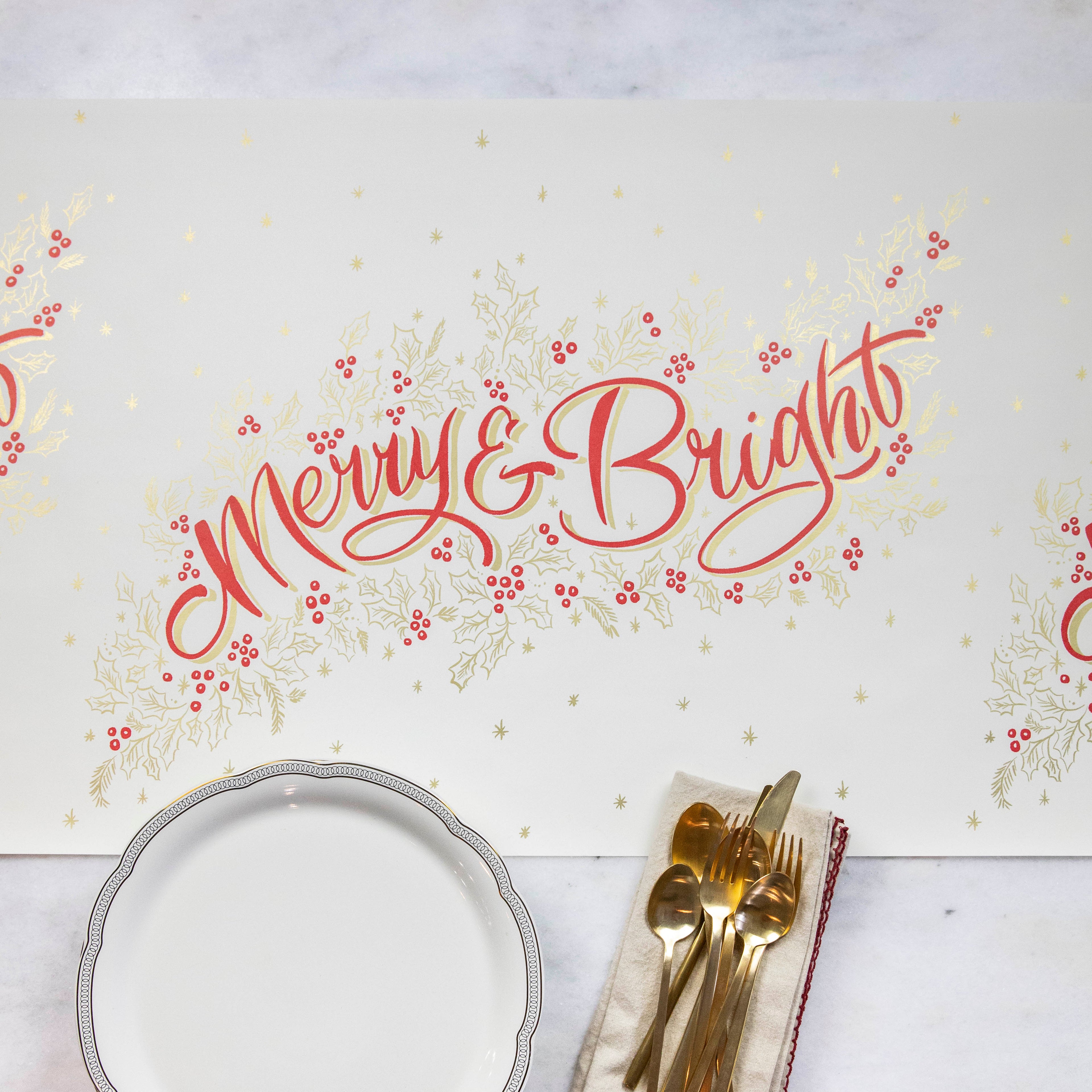 The Merry & Bright Runner on a white table with a plate, napkin and cutlery.