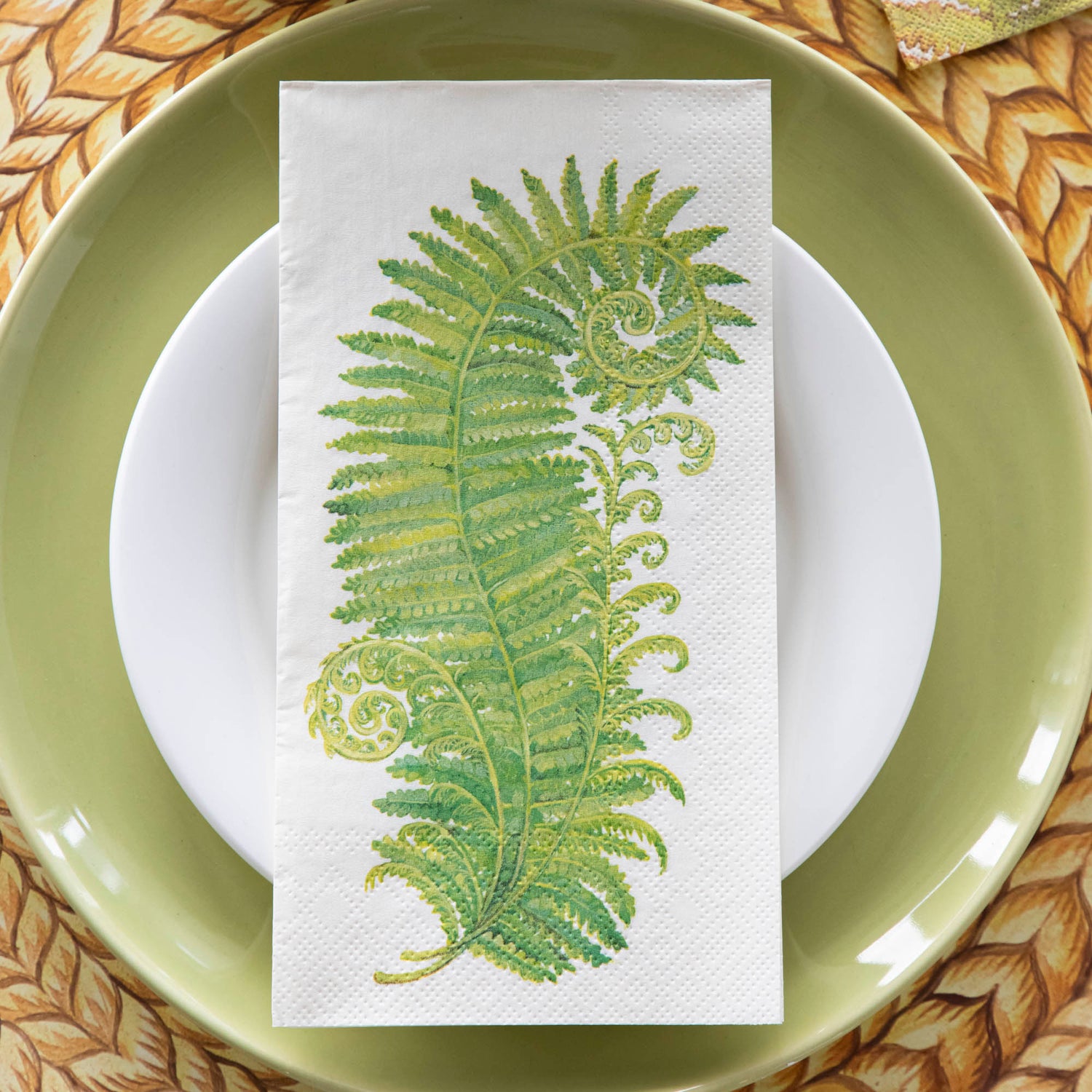 A Fern Guest Napkin on a place in an elegant place setting, from above.