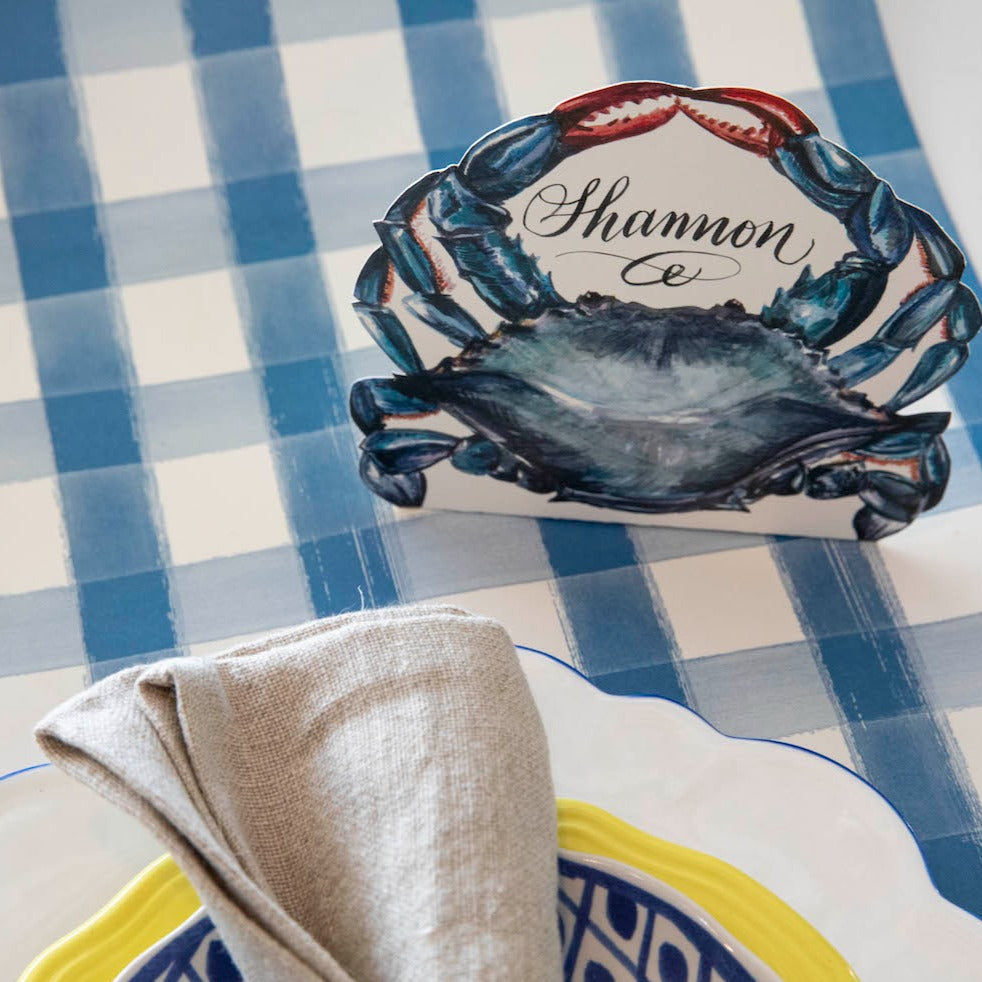 A Crab Place Card reading &quot;Shannon&quot;, set in front of a plate in a nautical-themed place setting.