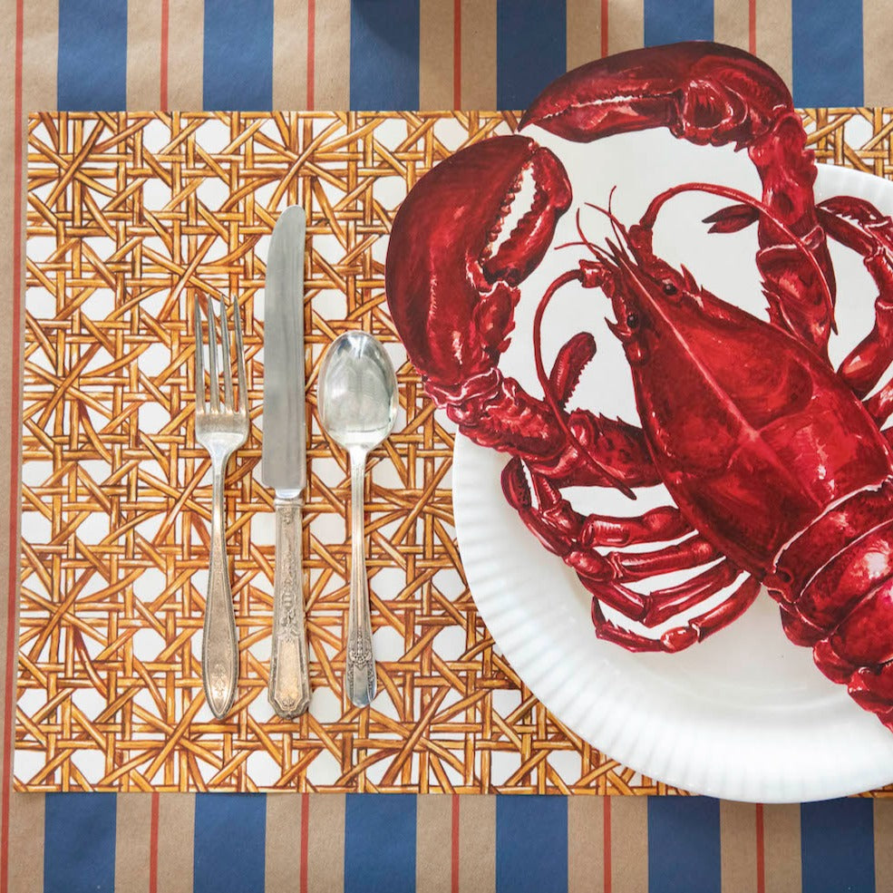 The Rattan Weave Placemat under a nautical-themed place setting, from above.