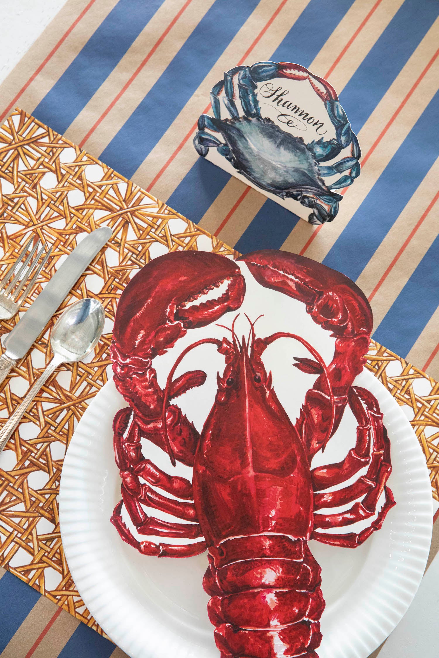The Kraft Navy &amp; Red Awning Stripe Runner under a nautical-themed place setting, from above.