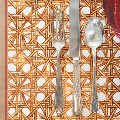 Close-up of the Rattan Weave Placemat under a nautical-themed place setting, showing the illustrated pattern in detail.