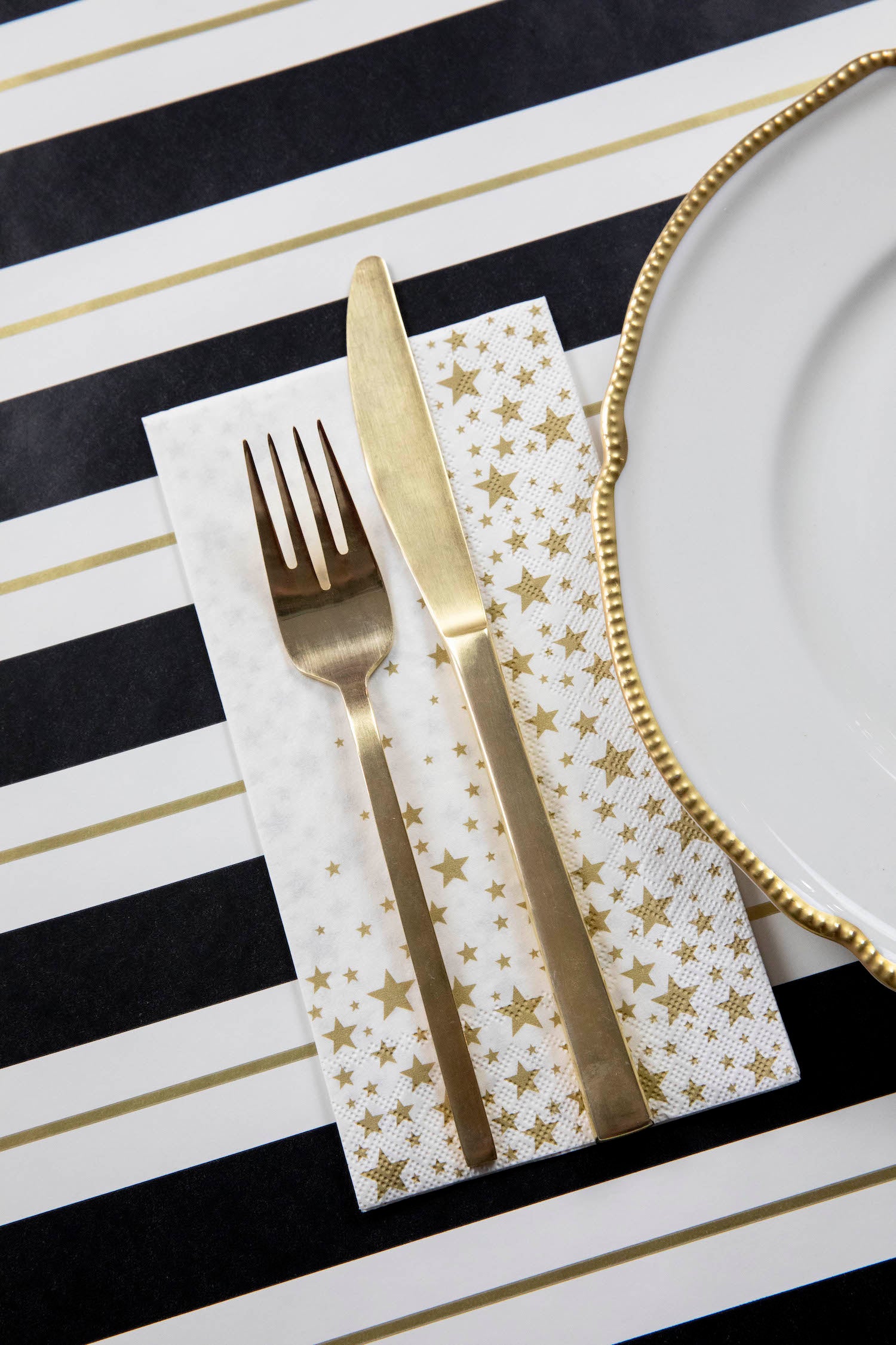 An elegant place setting with a Shining Star Guest Napkin next to the plate.