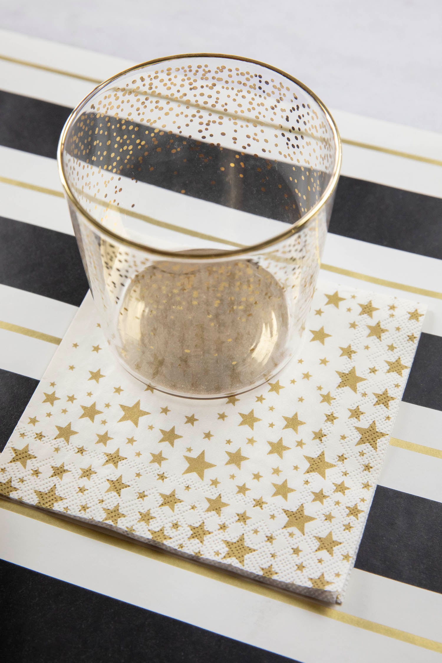 A Shining Star Cocktail Napkin under the water glass of an elegant place setting.