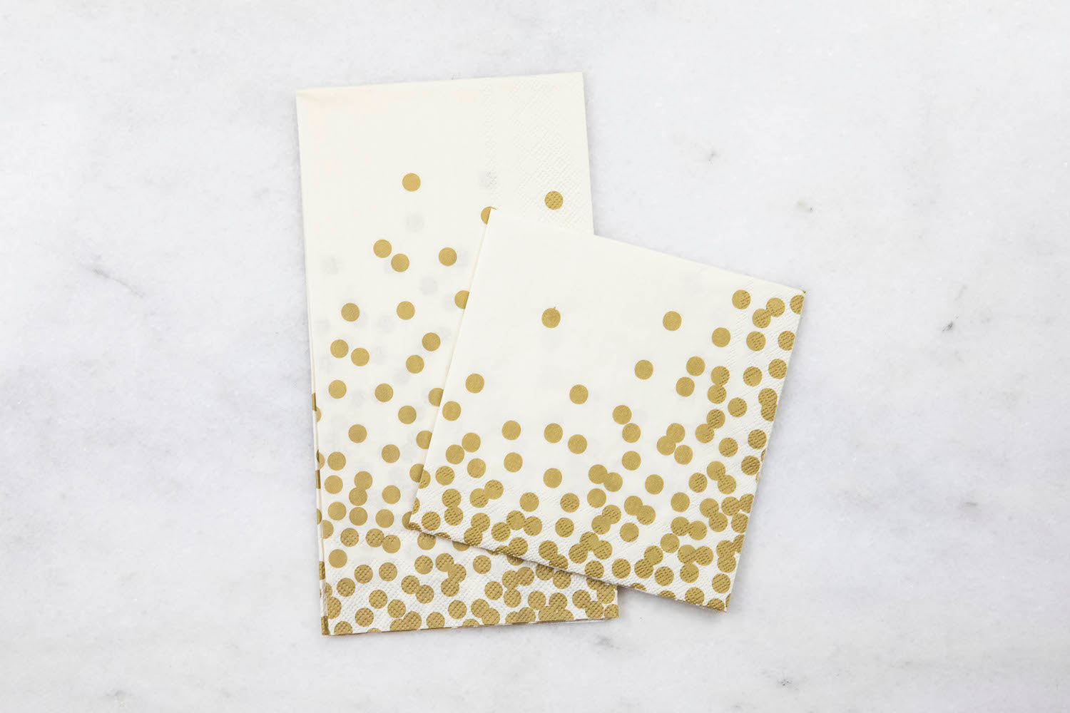 Two Gold Confetti Napkins, one Guest and one Cocktail, together on a white table.