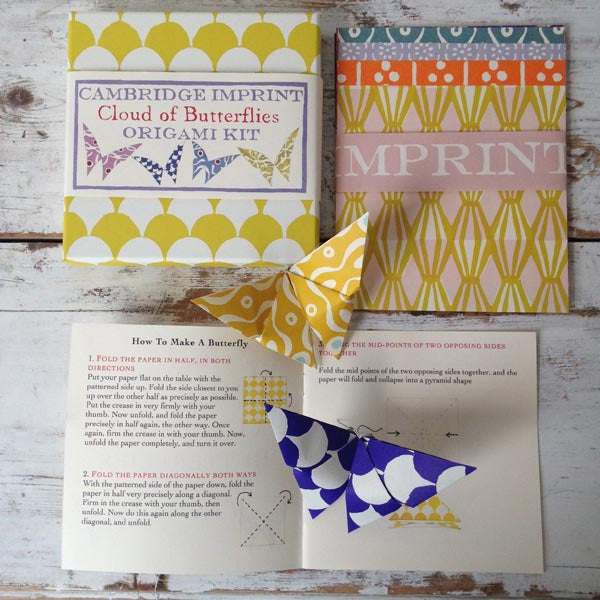 Origami Cloud of Butterflies Kit with instructions and Cambridge Imprint patterned paper on a wooden table.