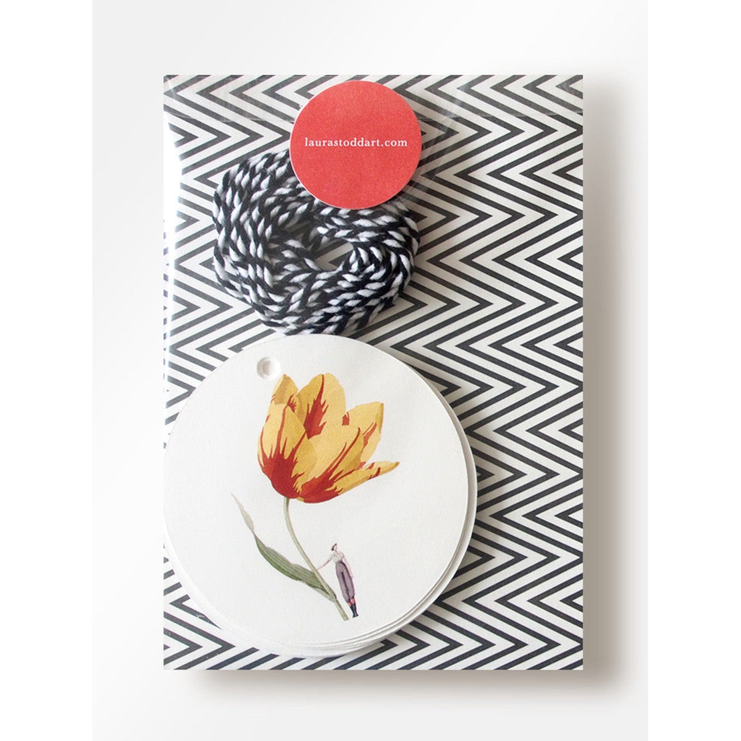 The In Bloom Gift Tags in retail packaging, showing a whimsical illustration and black and white strings for each gift tag.