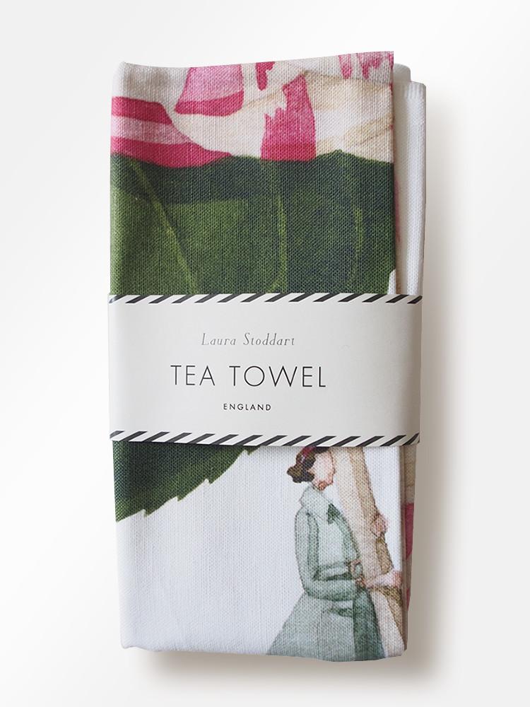 A In Bloom Camellia Linen Tea Towel by Hester &amp; Cook featuring botanical illustrations of a woman holding a pink flower.