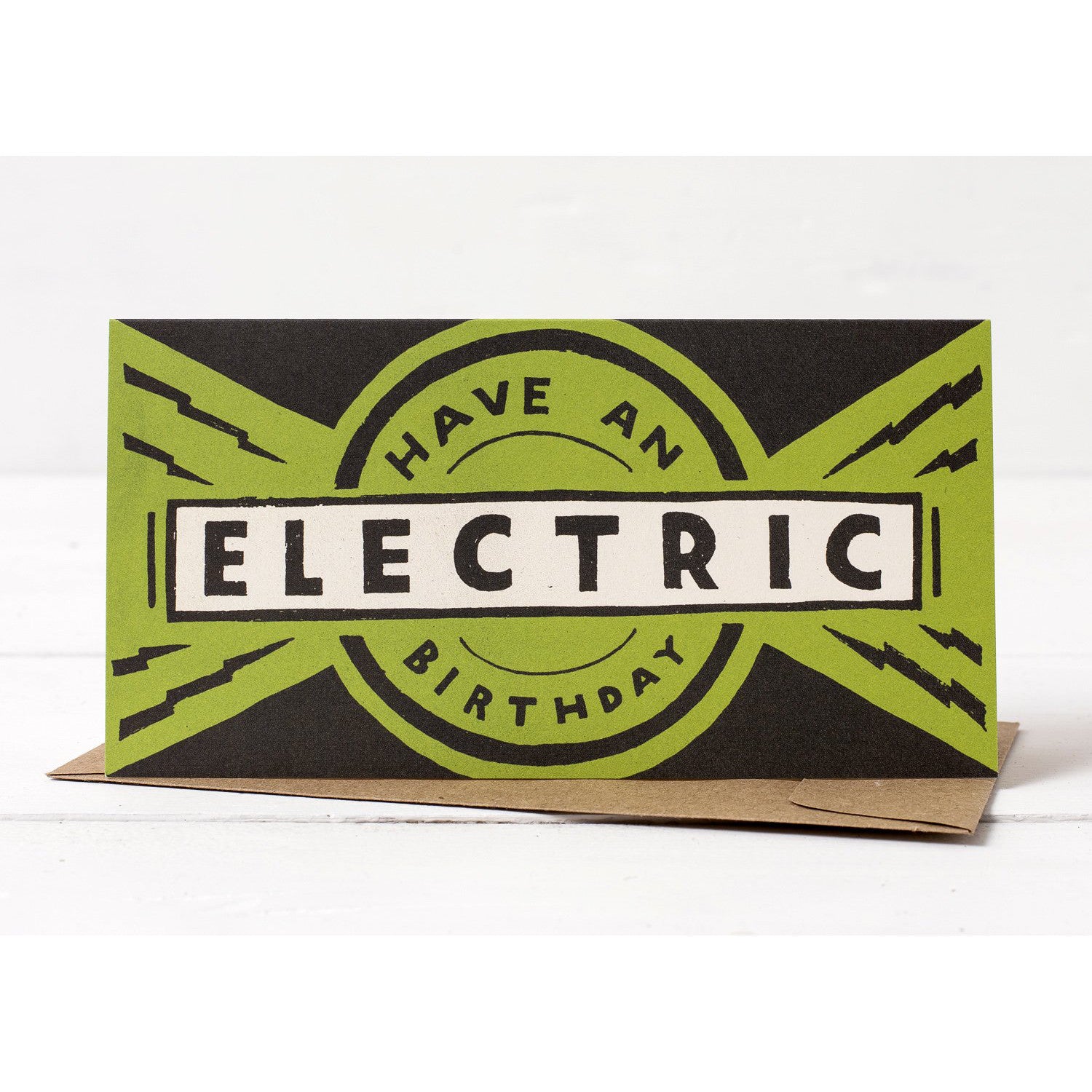 A Hester & Cook birthday card with the phrase "Have an Electric Birthday" styled in bold, retro, hand-lettered font against a green and black starburst background.