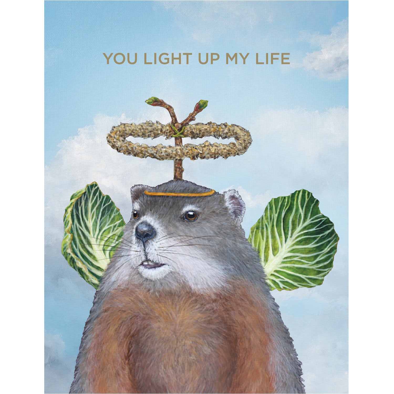 A greeting card featuring a whimsical illustration of a groundhog wearing cabbage leaf wings and a botanical halo on a cloudy sky background, with the words "YOU LIGHT UP MY LIFE" printed in gold.