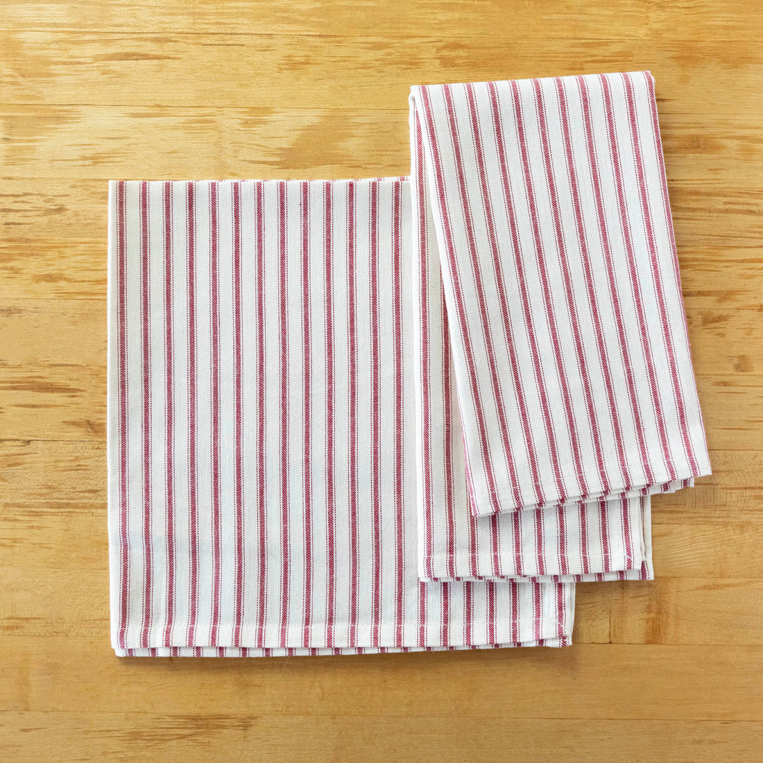 A Taylor Linen Bergen Red Napkin folded on a marble surface for everyday use.