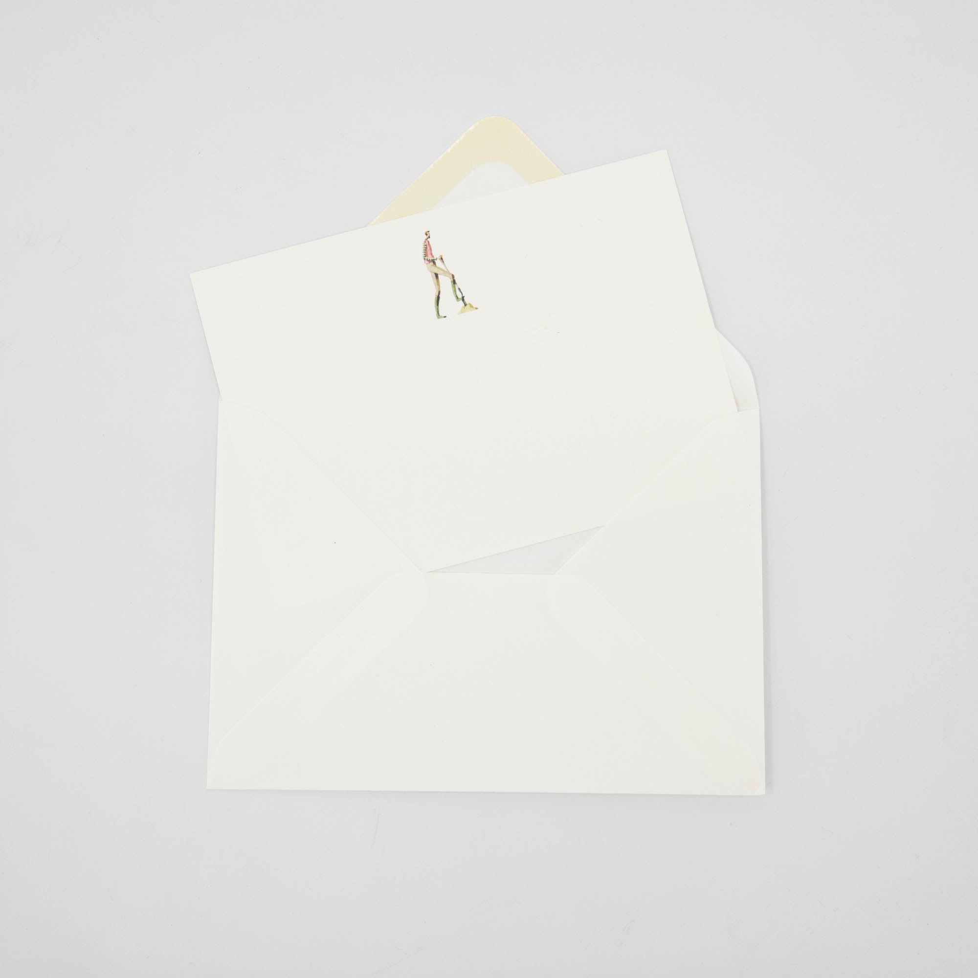 An illustrated Laura Stoddart note card tucked partway into a white envelope.