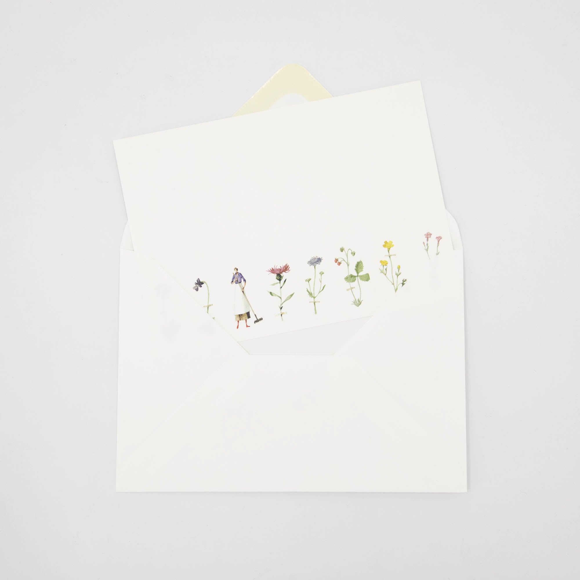 An illustrated Laura Stoddart note card tucked partway into a white envelope.